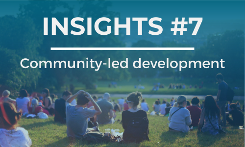 A group of people sit on an elevated hill with a city in the background. The text overlay reads 'INSIGHTS #7' at the top and 'Community-led development' below it, in white font against a blue background."